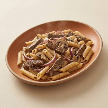 Pasta Steak Deluxe mit Rindersteakstreifen, rote Zwiebeln, cremige Pfeffer-Sahnesoße, Champignons